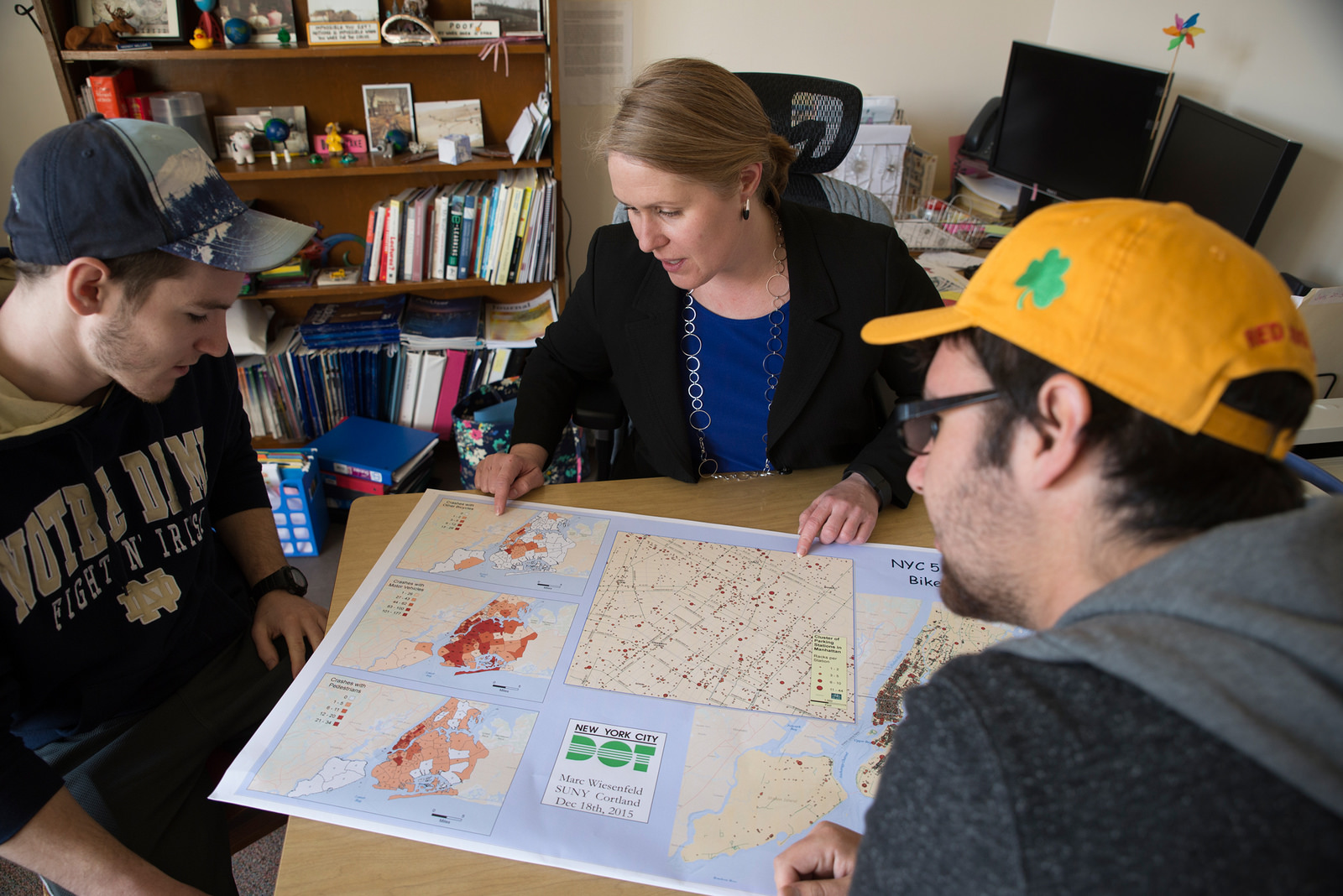 Students and professor looking at a map